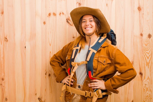 Jeune jolie femme voyageur latine contre le mur en bois