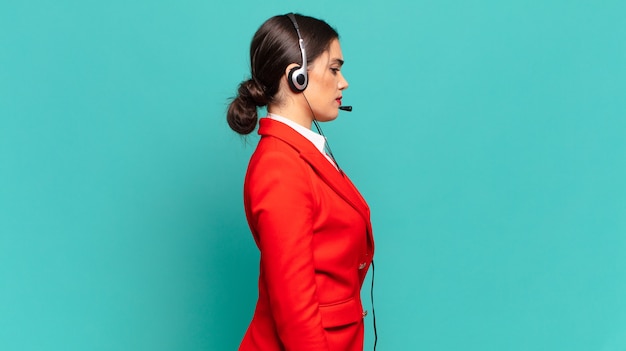 jeune jolie femme en vue de profil cherchant à copier l'espace à venir, à penser, à imaginer ou à rêvasser. concept de télévendeur