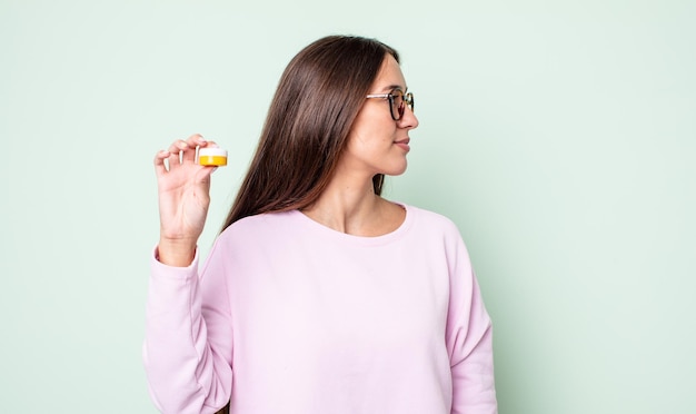 Jeune jolie femme sur la vue de profil pensant imaginer ou rêvasser concept de lentilles de contact