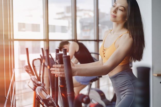 Jeune Jolie Fille Au Gymnase Sur Le Vélo, Fitness Et Yoga