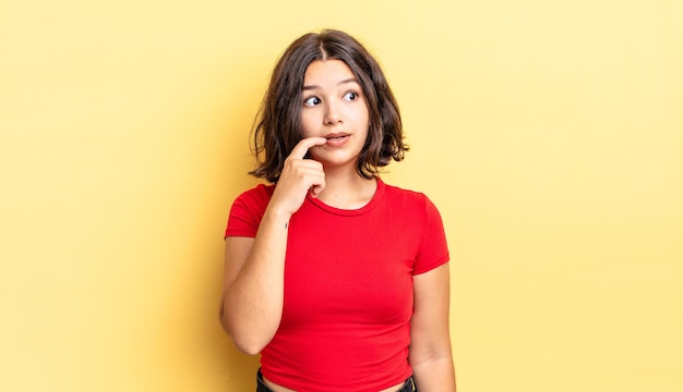 Jeune jolie fille au regard surpris, nerveux, inquiet ou effrayé, regardant sur le côté vers l'espace de copie