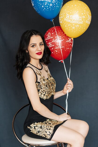 Jeune jolie fille avec des ballons à la main pour son anniversaire