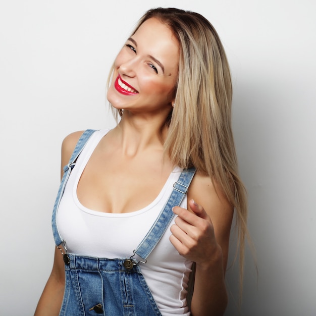 Jeune jolie fille blonde souriante sur fond blanc