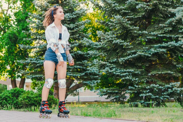 Jeune jolie fille patinage dans le parc