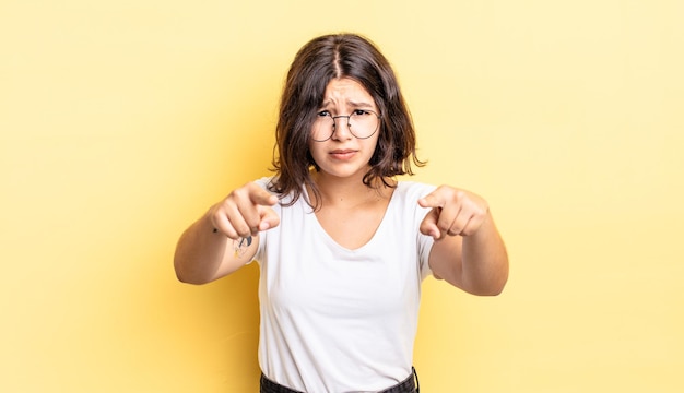 Jeune jolie fille pointant vers la caméra avec les deux doigts et une expression de colère, vous disant de faire votre devoir