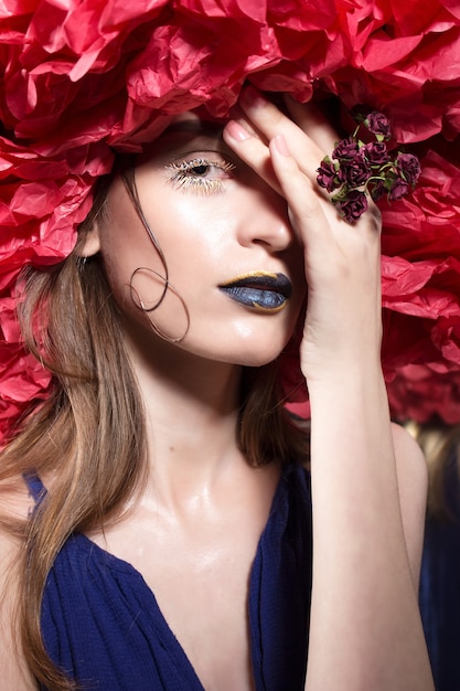 Jeune jolie fille portant un maquillage étrange et lumineux à la fête d'Halloween.