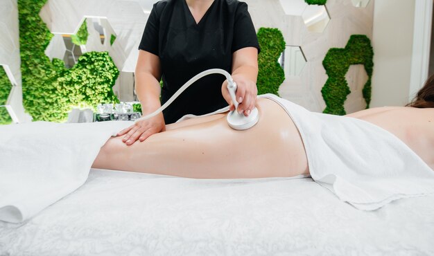 Une jeune jolie fille profite d'un massage sous vide professionnel au Spa. Soin du corps. Salon de beauté.