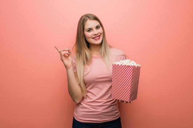 Jeune jolie fille russe pointant sur le côté avec le doigt.