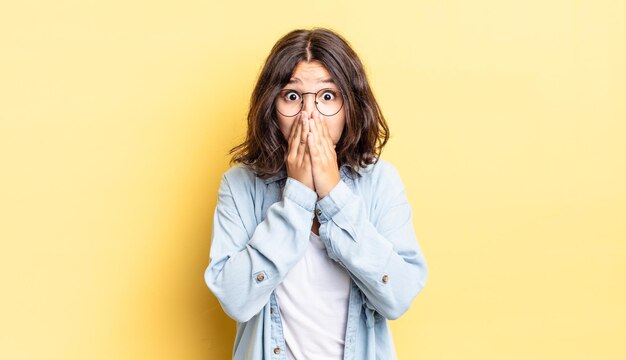 Jeune jolie fille se sentant inquiète bouleversée et effrayée couvrant la bouche avec les mains semblant anxieuse et ayant foiré