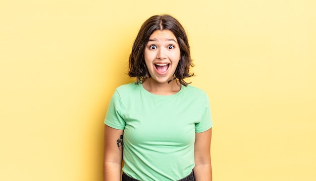 Jeune jolie fille semblant très choquée ou surprise, regardant la bouche ouverte en disant wow