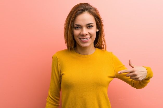 Jeune jolie jeune femme personne pointant à la main vers un espace copie de chemise, fière et confiante