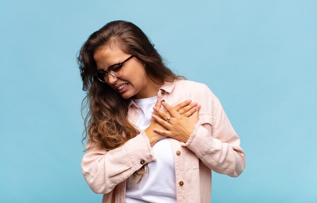 jeune jolie jeune jolie femme faisant des gestes sur le mur bleu