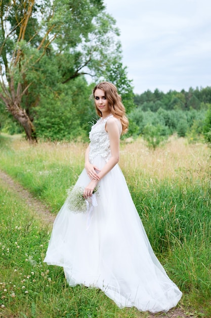 Jeune jolie mariée en robe de mariée blanche à l'extérieur