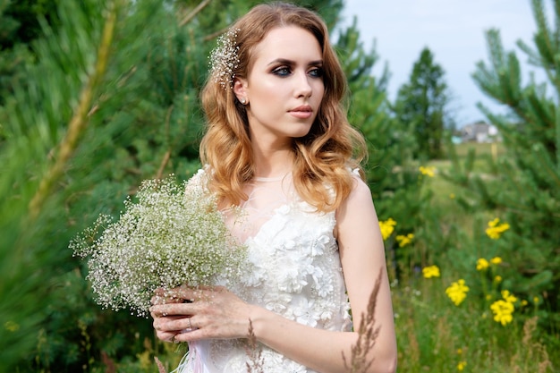 Jeune jolie mariée en robe de mariée blanche à l'extérieur