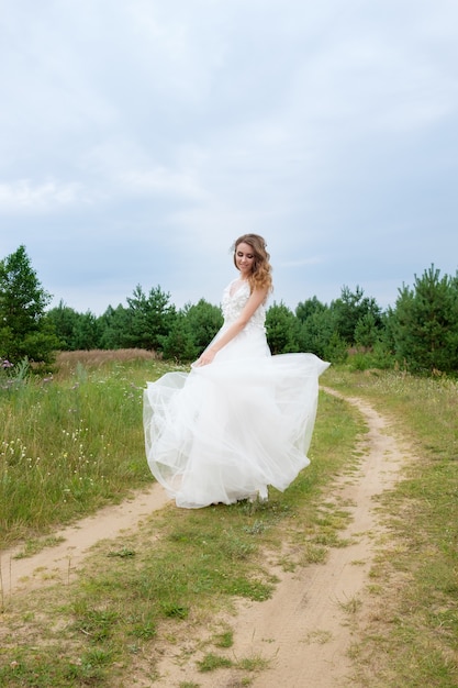 Photo jeune jolie mariée en robe de mariée blanche tourner autour