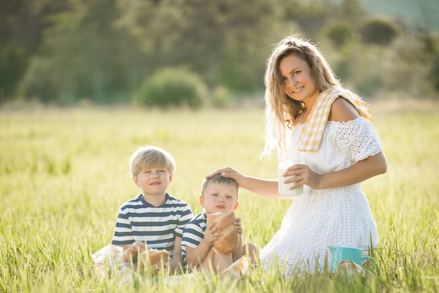 Jeune jolie mère pique-nique avec ses petits enfants. Famille, boire, lait, Dehors