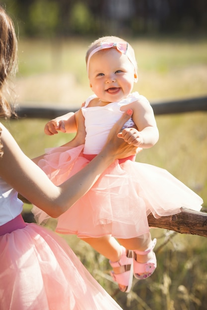 Jeune jolie mère avec son petit bébé à l'extérieur. Belle femme avec sa fille sur la nature. enfant en bas âge avec ses parents