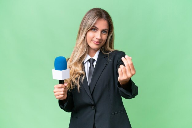 Jeune jolie présentatrice de télévision uruguayenne sur fond isolé faisant un geste d'argent