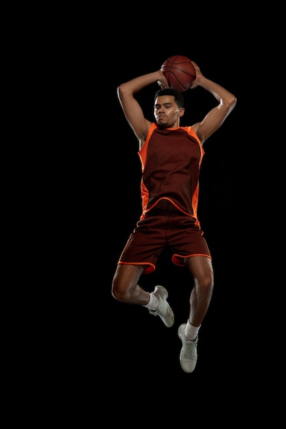 Jeune joueur de basket-ball afro-américain déterminé s'entraînant en action