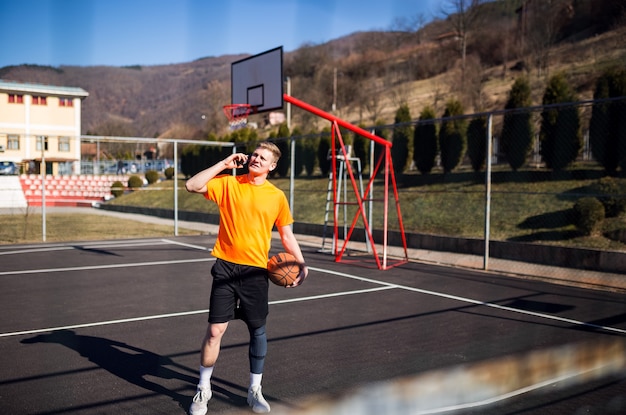 Photo jeune joueur de basket-ball utilisant le téléphone