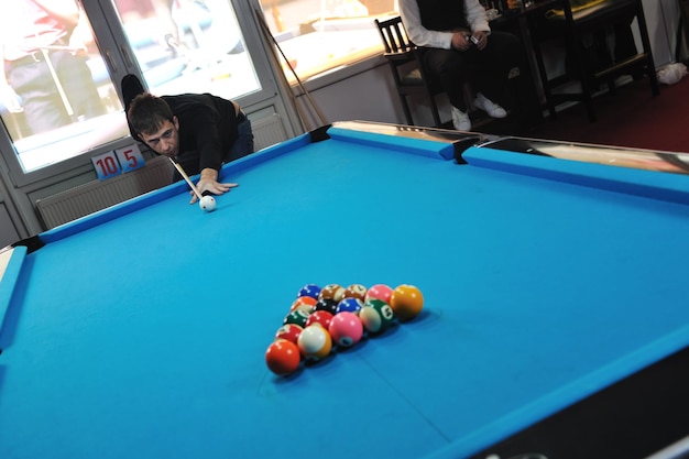 jeune joueur de billard professionnel trouvant la meilleure solution et l'angle droit au jeu de sport de billard ou de snooker