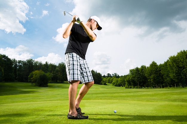 Jeune joueur de golf sur le parcours de golf swing