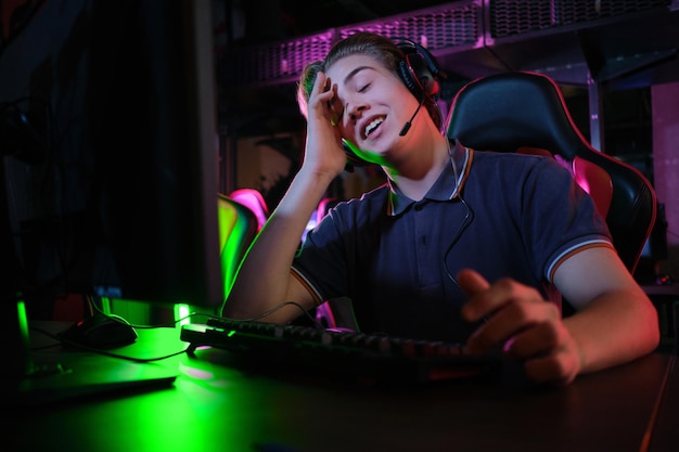 Jeune joueur professionnel de race blanche jouant en ligne sur son ordinateur, il a été contrarié par la perte du jeu