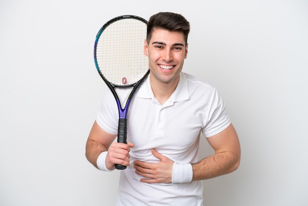 Jeune joueur de tennis homme isolé sur fond blanc souriant beaucoup