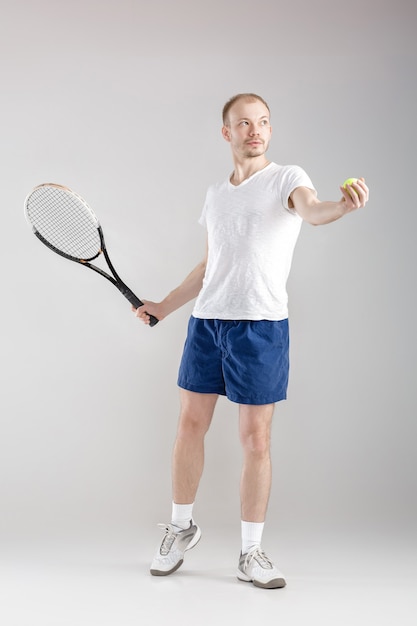 Le jeune joueur de tennis joue au tennis sur un gris