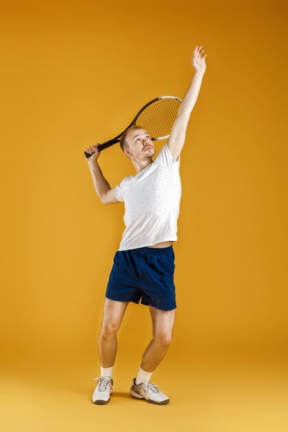 Le jeune joueur de tennis joue au tennis sur un jaune