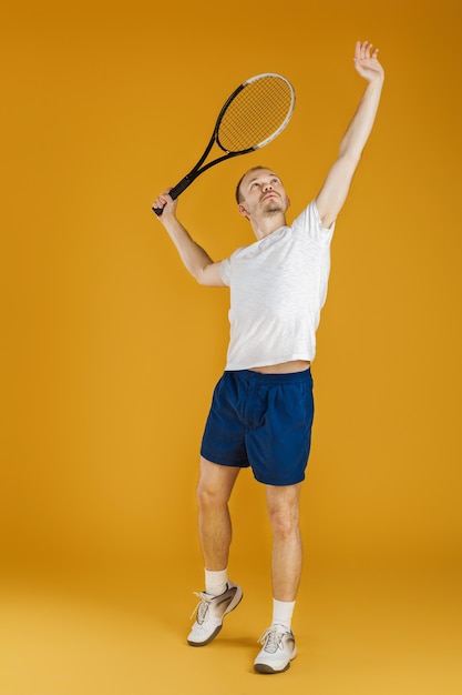 Le jeune joueur de tennis joue au tennis sur un jaune