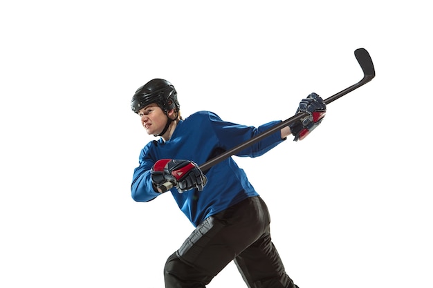 Jeune joueuse de hockey avec le bâton sur la glace et le mur blanc