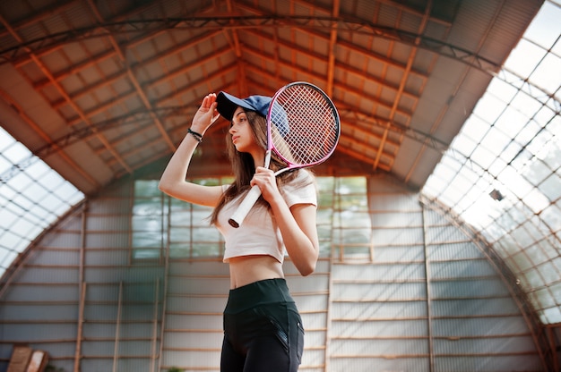 Jeune joueuse sportive avec une raquette de tennis sur un court de tennis.