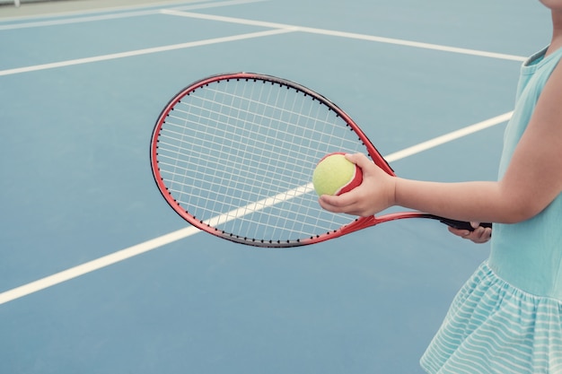 Jeune joueuse de tennis asiatique sur un court bleu