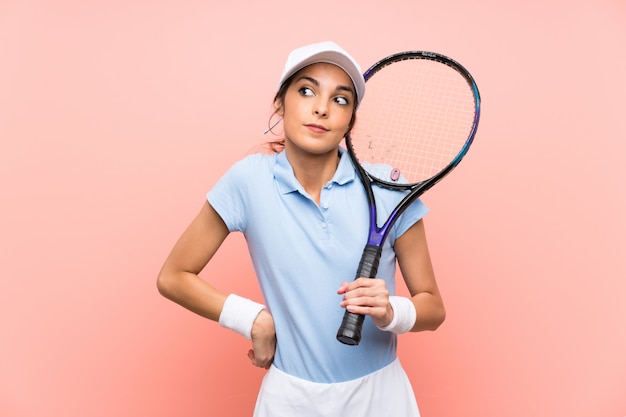 Jeune joueuse de tennis faisant des gestes de doutes tout en soulevant les épaules