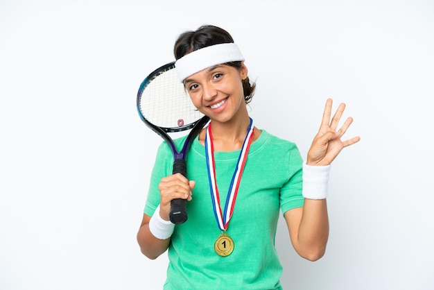 Jeune joueuse de tennis femme isolée sur fond blanc heureuse et comptant quatre avec les doigts