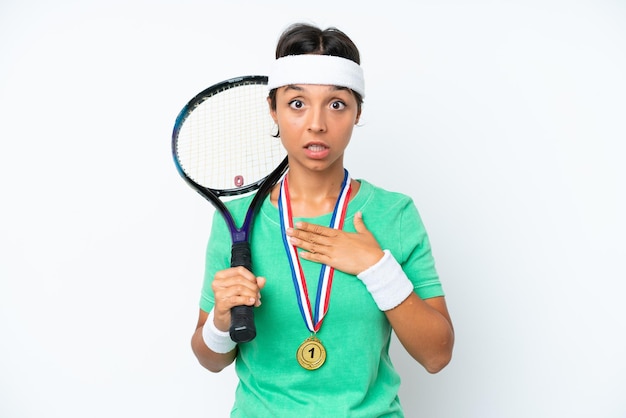 Jeune joueuse de tennis isolée sur fond blanc surprise et choquée en regardant à droite