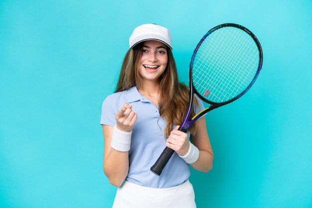 Jeune joueuse de tennis isolée sur fond bleu surprise et pointant vers l'avant