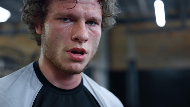 Jeune kickboxeur se reposant au gymnase Combattant debout dans un centre de fitness