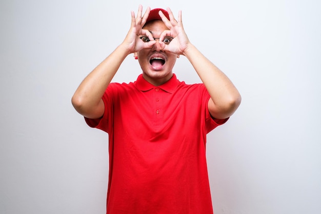 Jeune livreur asiatique portant une casquette avec un grand sourire faisant ok signe pouce vers le haut avec les doigts excellent signe