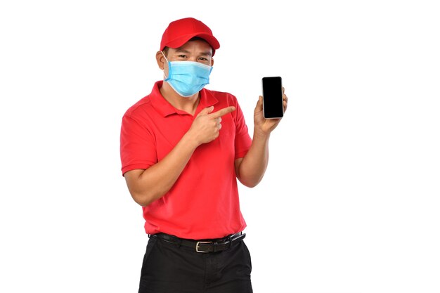 Jeune livreur asiatique en uniforme rouge, masque médical, gants de protection tenant et introduisant l'utilisation du téléphone intelligent