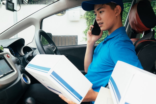 Photo jeune livreur vérifiant la liste des clients