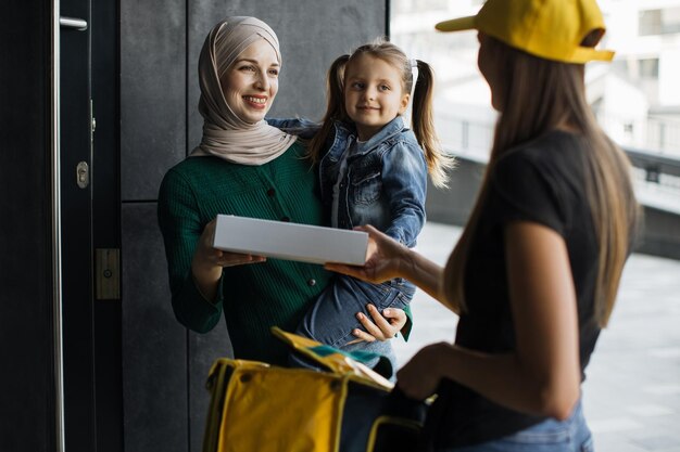 Jeune livreuse avec casquette jaune et sac à dos ce nouveau style normal par service express