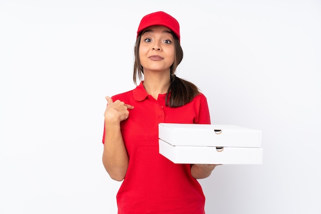 Jeune livreuse de pizza sur fond blanc isolé avec une expression faciale surprise