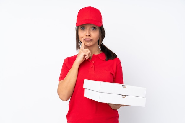 Jeune livreuse de pizza sur mur blanc isolé et à l'avant