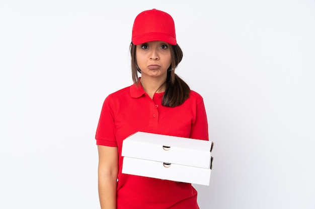 Jeune livreuse de pizza sur un mur blanc isolé avec une expression triste et déprimée