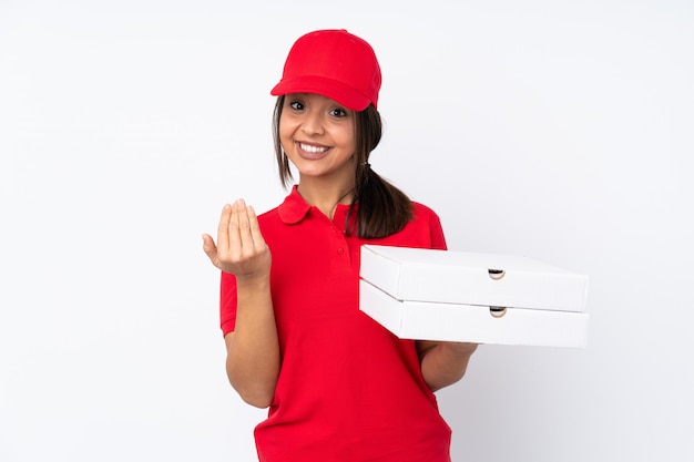 Jeune livreuse de pizza sur un mur blanc isolé invitant à venir avec la main. Heureux que tu sois venu