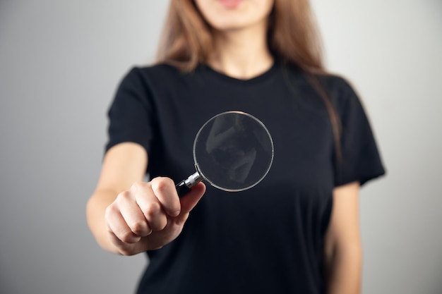 Jeune main féminine avec une loupe