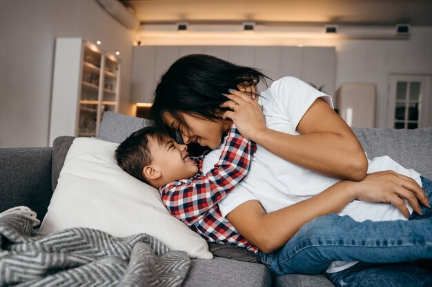 Photo jeune maman afro-américaine embrasse tendrement son fils bien-aimé