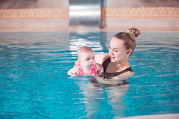 Jeune maman apprend à son enfant à nager